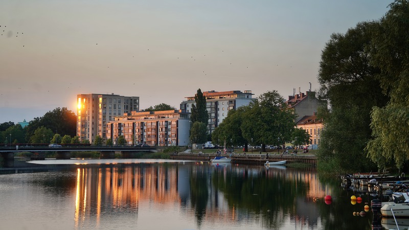 Södra Kristianstad från Helge å. Båtklubben, Lastageplatsen och solnedgång över kvarteret Finland.
