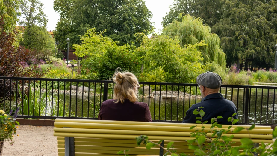 En man och en kvinna som sitter på en gul bänk.