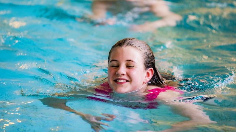 Flickor simtränar i bassängen på Kristianstads badrike