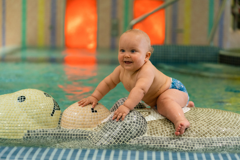 Bebis klättar på Uttern i barnbassängen på Kristianstads badrike