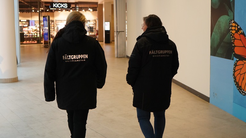 2 kvinnor i svarta jackor med text "Fältgruppen" på ryggen.