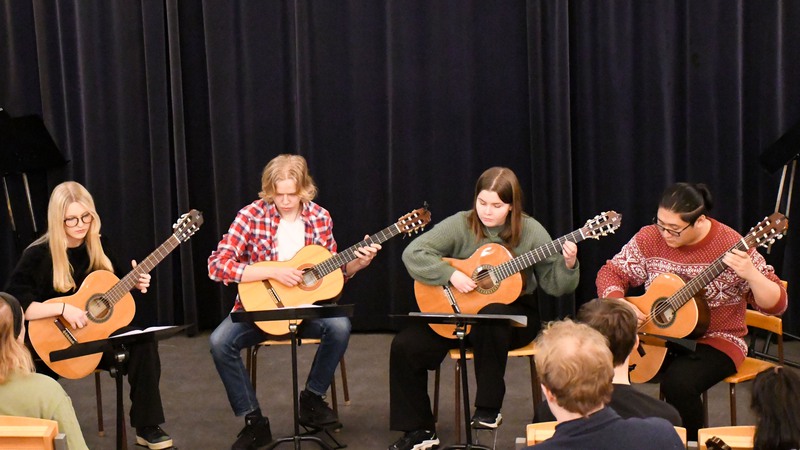 Eleverna i Kristianstads Gitarrensemble spelar på konsert i C4-gymnasiets Aula. 